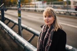 Elisabeth Becker im dunklen Mantel an einem Brückengeländer über einer Stadtautobahn in Berlin Alex Sobotta Fotograf